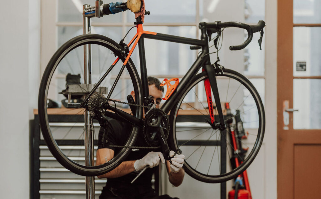 Un technicien vélo réparant un vélo dans son atelier en Alsace